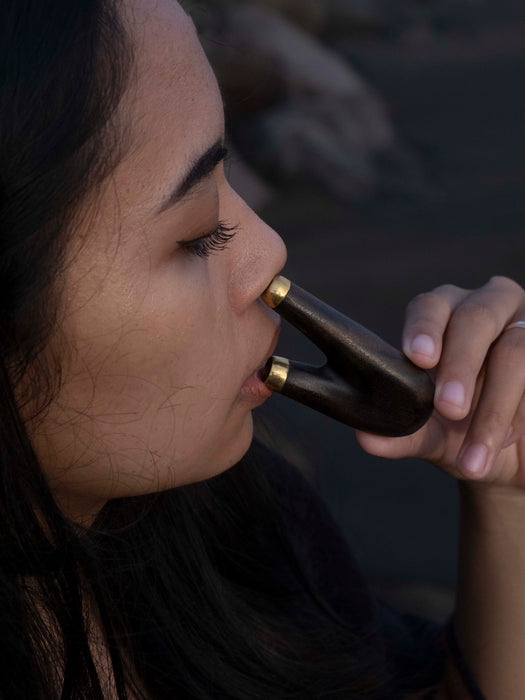 Person holding a bottle to their mouth with a blurred background