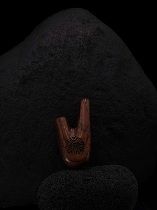 Wooden tool with a textured design on a dark stone surface