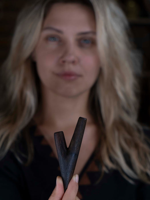 Woman holding a wooden V-shaped object with a blurred background