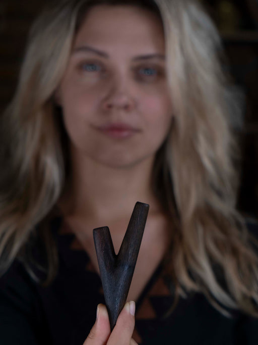 Woman holding a wooden V-shaped object with a blurred background