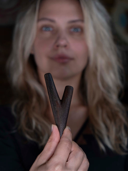 Person holding a wooden tool with a blurred background