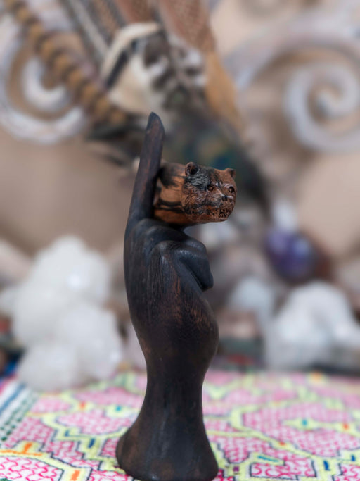 Decorative statue of a hand holding a small object against a blurred background
