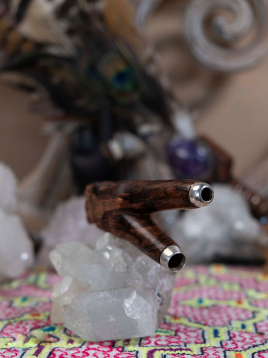 Wooden and metal pipe on a crystal base with a colorful fabric background