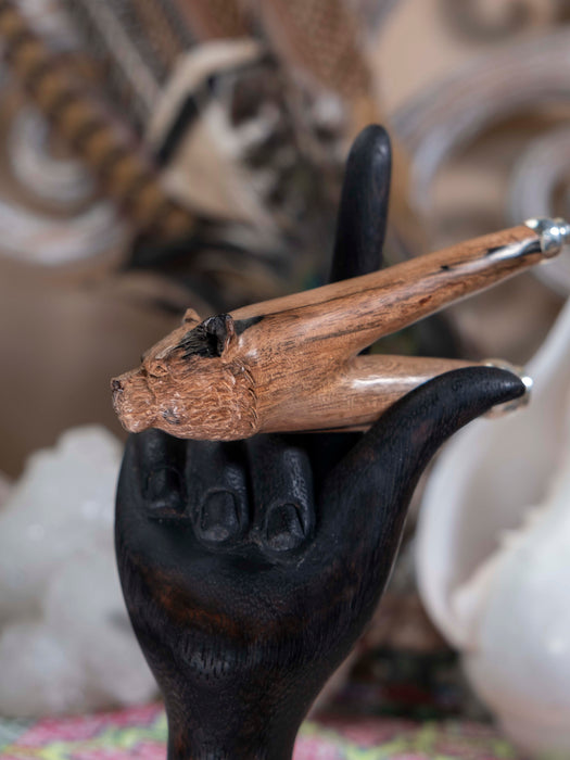 Decorative object with a black hand holding a wooden stick against a blurred background