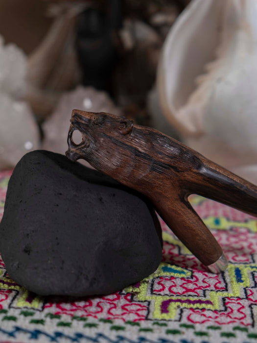 Wooden tool on a black stone with a colorful fabric background