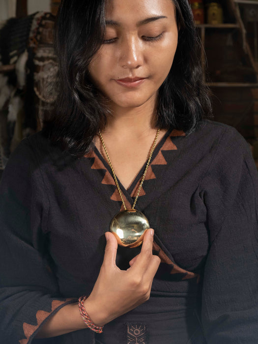 Woman holding a gold pendant with a blurred background