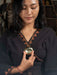 Woman holding a gold pendant with a blurred background