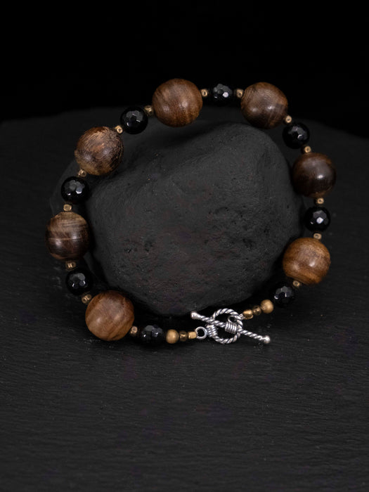 Bracelet with brown and black beads on a dark surface