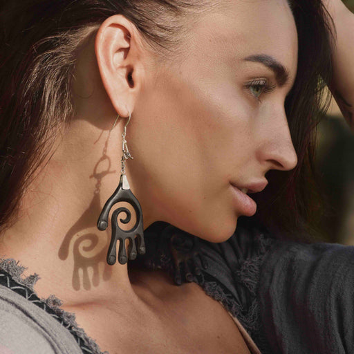 Cupped hands present the Buddha Hand - earrings set, exquisitely handcrafted from ebony and sterling silver, signifying spiritual guidance and protection.