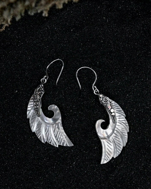 Exquisite Angel Wings earrings, crafted from lustrous mother-of-pearl and detailed sterling silver, radiating aesthetic grace and ethereal charm