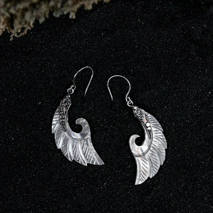 Exquisite Angel Wings earrings, crafted from lustrous mother-of-pearl and detailed sterling silver, radiating aesthetic grace and ethereal charm