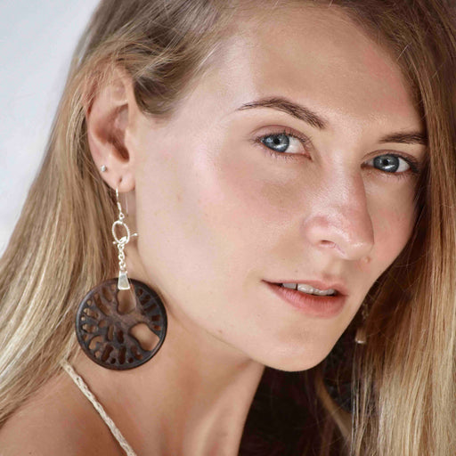 Woman adorned with a handcrafted rosewood and silver  Tree of Life pendant and matching earrings set, symbolizing spiritual unity and protection