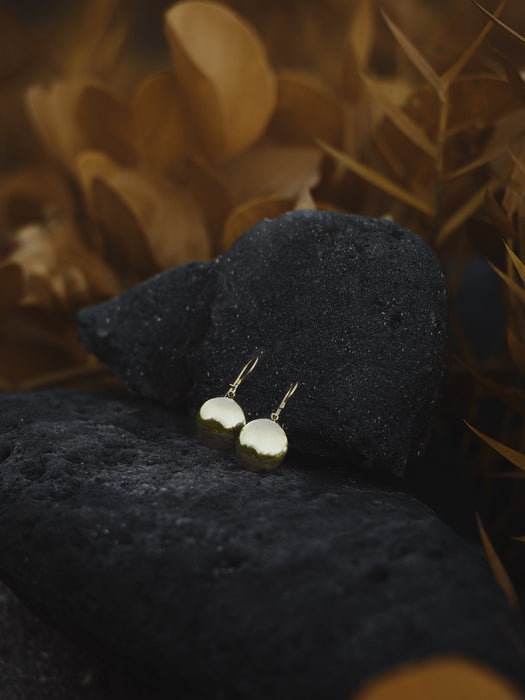 Matte bronze earrings with hammered textures and small mirrors, paired with terracotta jewelry.