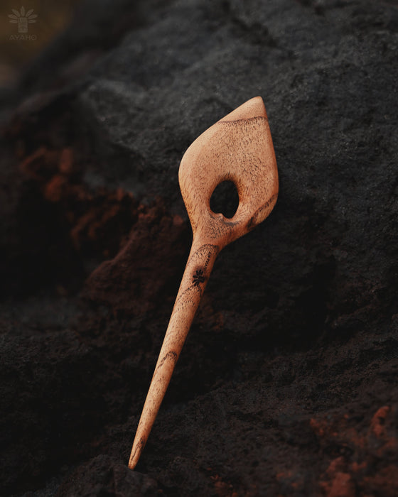 Hand-finished wooden hair clip with smooth edges, displayed on a bed of eucalyptus leaves to highlight its organic inspiration
