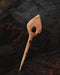 Hand-finished wooden hair clip with smooth edges, displayed on a bed of eucalyptus leaves to highlight its organic inspiration
