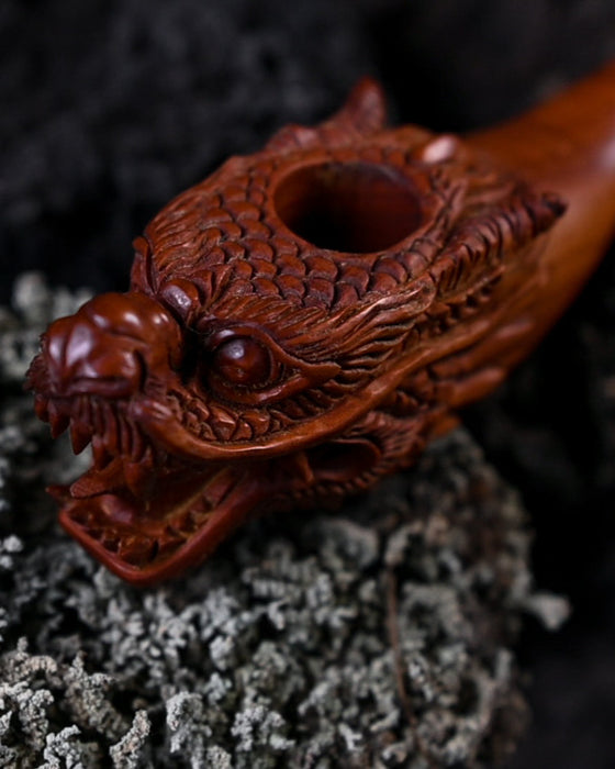 Handcrafted wood smoking pipe with elegant dragon carvings, combining quality and artistic flair.