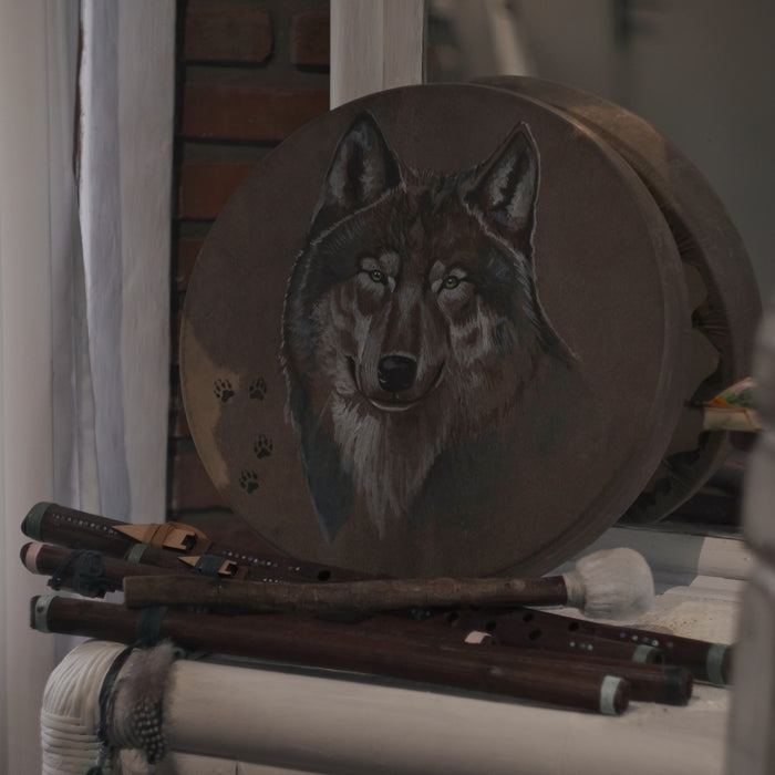 Handcrafted shaman drum featuring a striking wolf design, promoting deep spiritual connection and self-discovery.