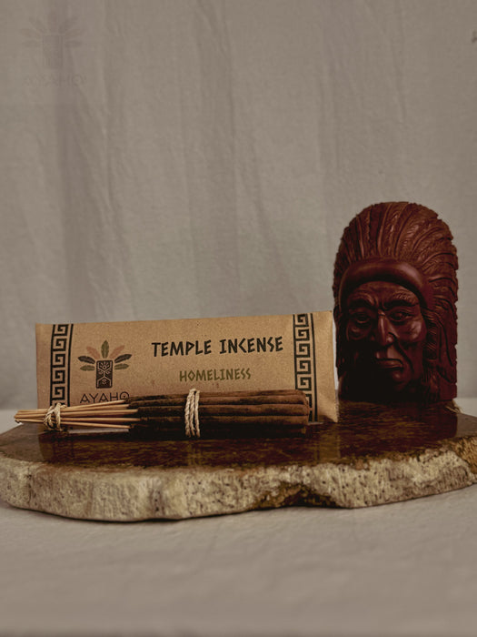 Temple incense set with packaging and wooden figure on a stone surface