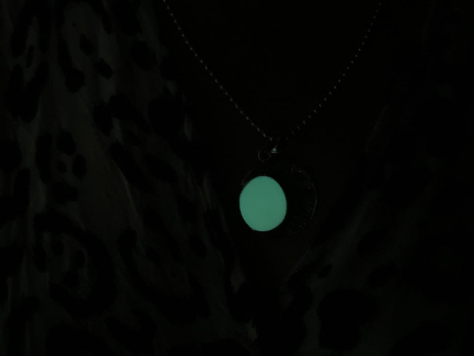Necklace with a glowing green pendant against a dark background