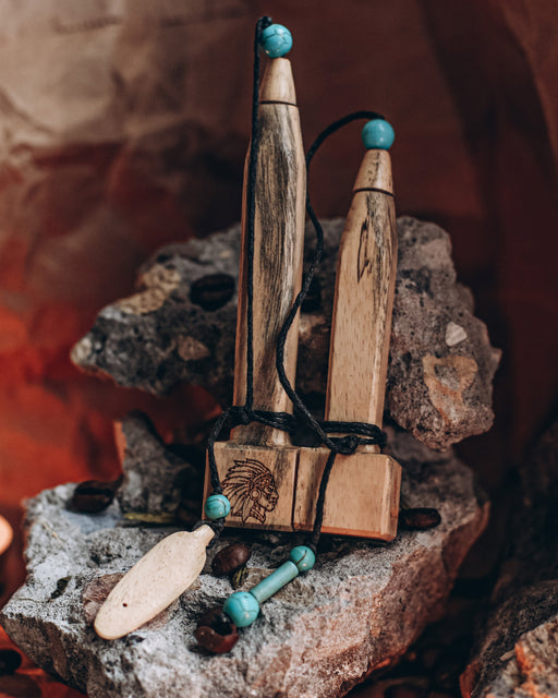 Hand-carved tamarind wood pipe with traditional Shipibo patterns and turquoise inlay, resting on ceremonial cloth