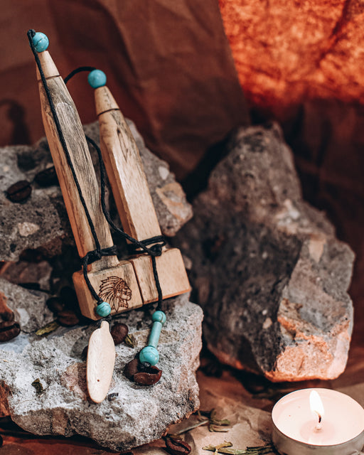 Hand-carved tamarind wood pipe with traditional Shipibo patterns and turquoise inlay, resting on ceremonial cloth