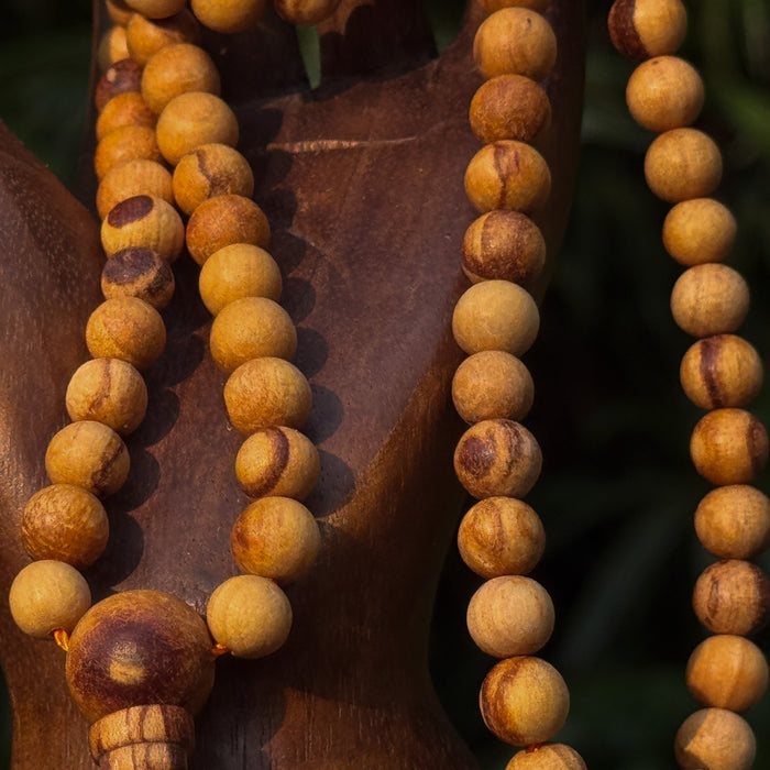 Close-up of a wooden beaded necklace on a dark background