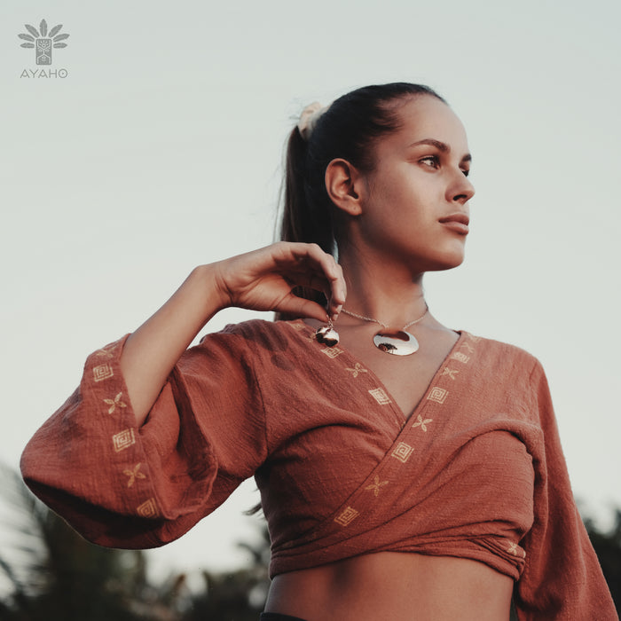 Woman wearing a rust-colored traditional outfit with a blurred background