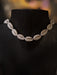 Necklace made of cowrie shells on a black mannequin with a blurred background