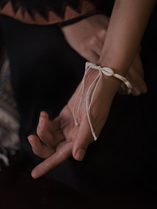 Close-up of a person's hand with a bracelet on a dark background