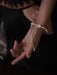 Close-up of a person's hand with a bracelet on a dark background