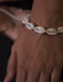 Close-up of a shell anklet on a person's ankle with a blurred background