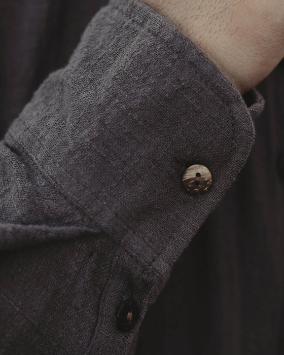 Man in a relaxed-fit brown cotton shirt with a mandarin collar, showcasing boho tribal fashion by the poolside
