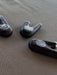 Three black earbud tips with a logo on a brown fabric background