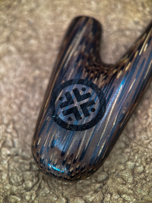 Wooden object with a decorative emblem on a textured surface