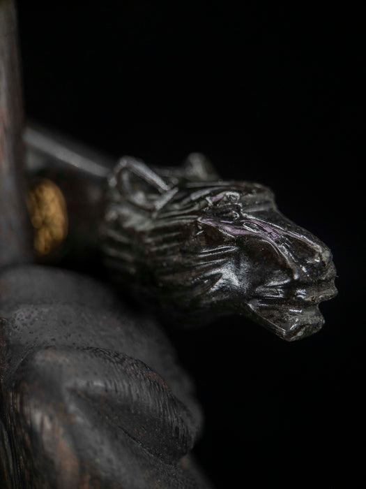 Close-up of a metallic object with a detailed design on a dark background