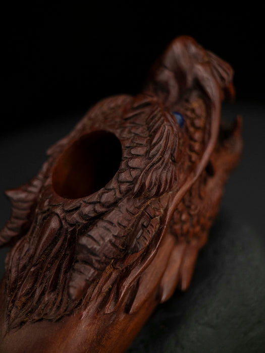 Wooden dragon head sculpture on a dark background