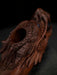 Wooden dragon head sculpture on a dark background