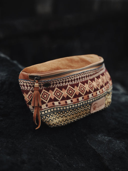 Artisan-crafted cotton belt bag featuring vibrant tribal designs, with multiple compartments and an adjustable strap for secure, stylish carry.