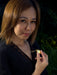 Woman holding a glowing yellow gemstone against a dark background