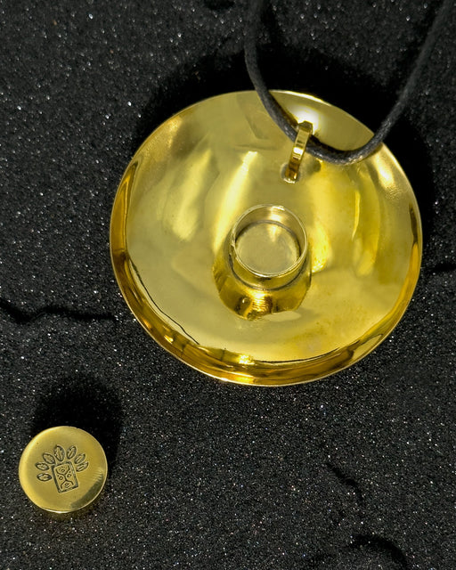 Gold pendant on a black textured background