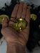 Hand holding a gold pendant with a blurred background