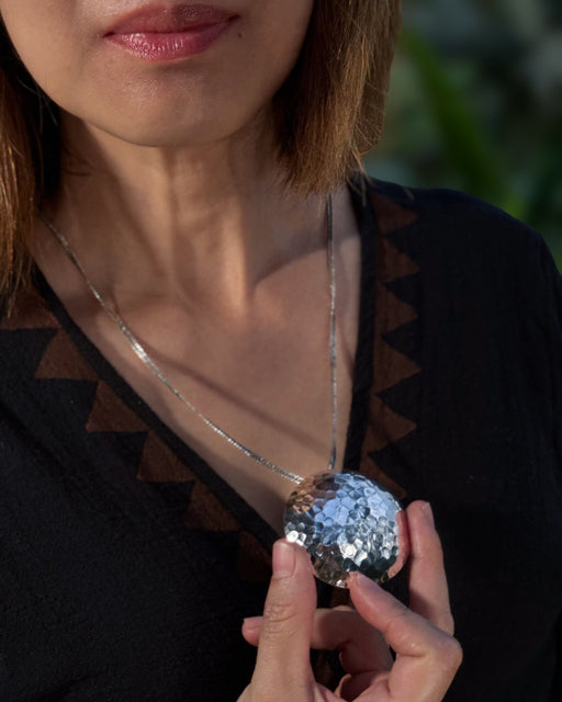 Person holding a silver sequin ball with a blurred background