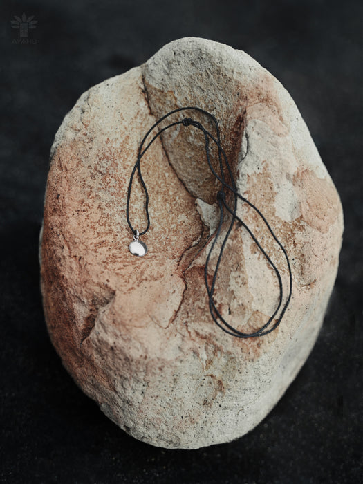 Necklace with a pendant on a textured stone surface