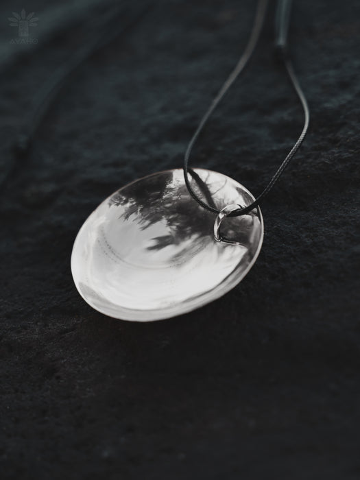 Silver pendant necklace on a dark textured background