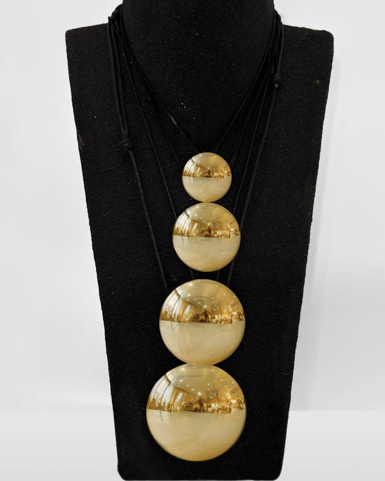 Gold necklace with three spherical pendants on a black mannequin bust.