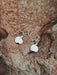 Silver earrings on a textured stone surface