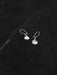 Silver earrings on a textured black surface