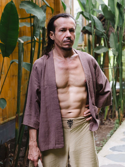 Man in traditional attire standing in a garden setting