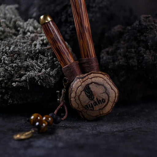 A hand presents a wooden kuripe pipe, meticulously handcrafted for hape snuff application This unique smoking accessory, with its necklace design and rustic charm, exemplifies traditional shamanic tools and doubles as a protective herbal medicine kit