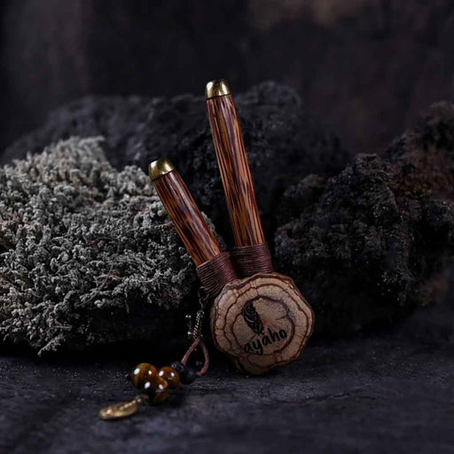 A hand presents a wooden kuripe pipe, meticulously handcrafted for hape snuff application This unique smoking accessory, with its necklace design and rustic charm, exemplifies traditional shamanic tools and doubles as a protective herbal medicine kit